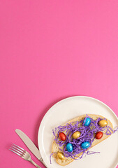 Sandwich with hay and Easter eggs in a plate on a pink background.
