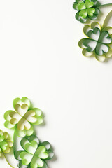 Green paper quilled clovers on a white background. St Patrick's Day vertical banner template,...