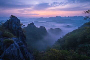 Serene mountain landscape at dawn with mist and vibrant sky colors.