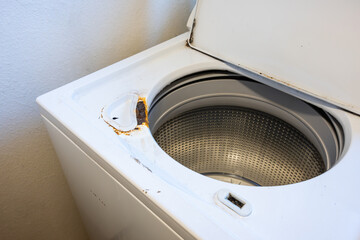 Laundry room appliances, washing machine with lid open showing rust and corrosion, rental home...