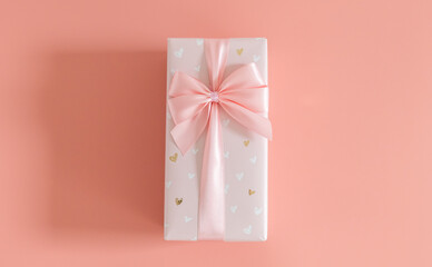 One gift box with a bow on a pink background.