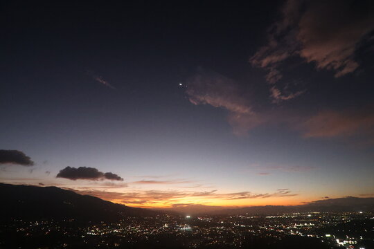 City Lights Under a Crescent Moon