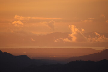 Orange Sunset Over Mountain Landscape with Clouds