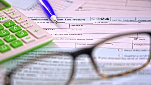 Individuals navigate the complexities of tax forms in preparation for the 2024 filing season. A calculator and pen emphasize the importance of accuracy and detail.