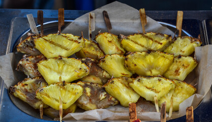 Delicious grilled pineapple skewers arranged on a tray, showcasing a fresh, tropical culinary presentation. Ideal for barbecue, tropical-themed, or fruit-forward culinary photography