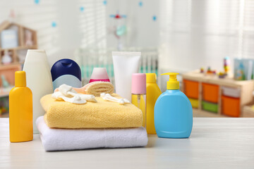 Baby cosmetic products and bath accessories on table in room