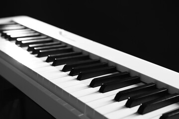 Synthesizer on black background, closeup. Electronic musical instrument
