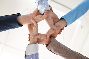 Obraz premium Teamwork. Group of people holding hands together indoors, bottom view