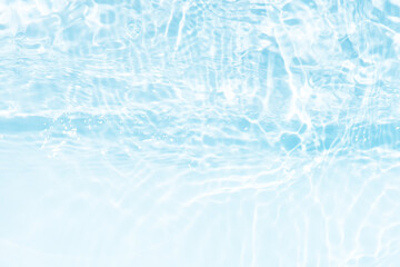 Blue water with ripples on the surface. Defocus blurred transparent blue colored clear calm water surface texture with splashes and bubbles. Water waves with shining pattern texture background.