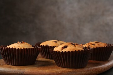 Delicious muffin with chocolate chips on table, closeup