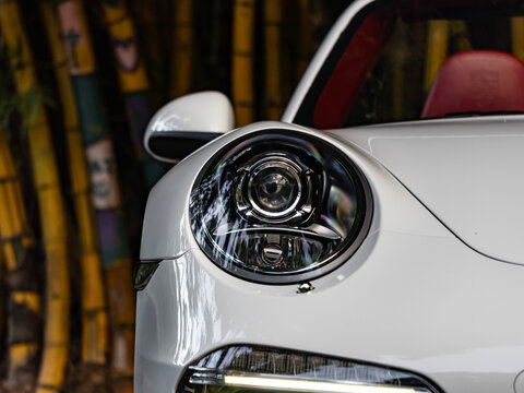 White Porsche 911 991.2 headlight close up shot, Luxury sports car external detail portrait