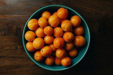 Fresh Apricots in Teal Bowl on Wooden Surface