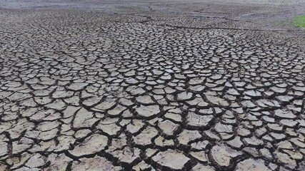 Dry and cracked gray soil ground during drought, viewed from above. top view. earthquake cracking holes, cracked wall, ground cracks top view, ruined land surface crushed texture. destruction