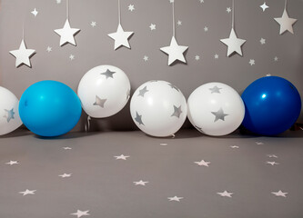 Generated image, decoración de set fotográfico para sesión fotográfica, con globos azules y globos blancos con estrellas, ciclorama gris adornado con estrellas blancas