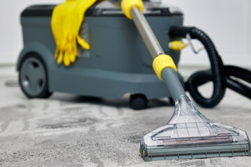 This image showcases an efficient wet and dry vacuum cleaner placed on a gray carpet in a house,...