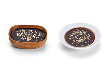 Tonkatsu dipping sauce sprinkled with white sesame seeds isolated on white background.