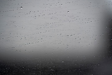 gotas de lluvia sobre vidrio de ventana de coche con fondo desenfocado de cielo gris
