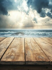Fototapeta premium A serene view of a wooden deck overlooking a stormy ocean under dramatic clouds and sunlight breaking through.