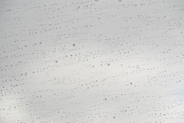 vidrio de ventana con textura de gotas de lluvia con un cielo gris