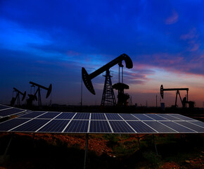 Oil pump with solar panels in the sunset