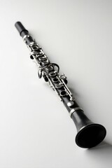 Fototapeta premium A Sleek Black Clarinet Resting on a Plain White Surface, Ready for a Musical Performance