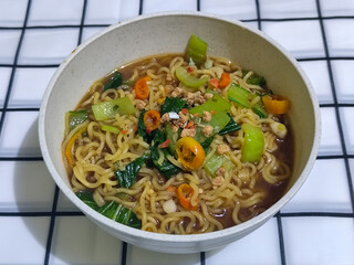 Soy sauce fried noodles served with pickles, chilies, vegetables, etc.