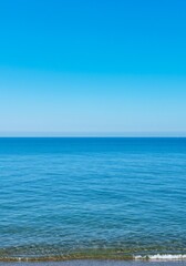 Fototapeta premium Calm Ocean Water and Clear Blue Sky on a Peaceful Beach