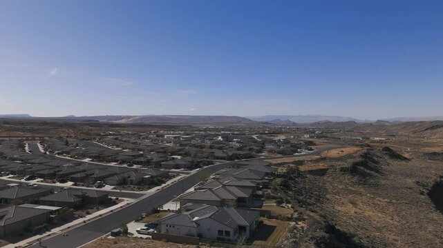 TOQUERVILLE FALLS, UTAH, USA - February 07, 2025: Flying over a subdivision in the town of Hurricane, Utah on the edge of black igneous basalt cliffs overlooking the Virgin River Gorge 