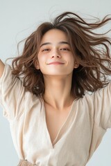 Naklejka premium Joyful Young Woman with Wavy Hair Expressing Happiness and Freedom