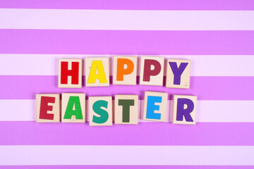 Word HAPPY EASTER spelled in colorful wooden beads on purple