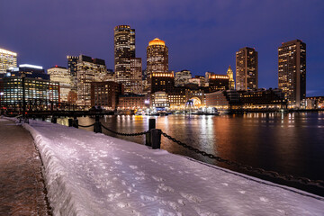 View of Boston downtown  skyscrapers seen from Fan Pier Park on a cold cloudy winter night