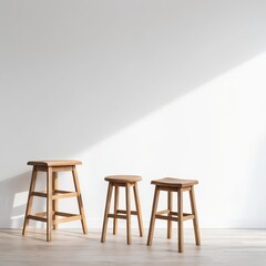 Three Wooden Stools Against White Wall