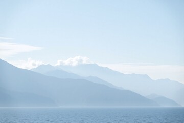 Landscape of mountain range in fog with calm water