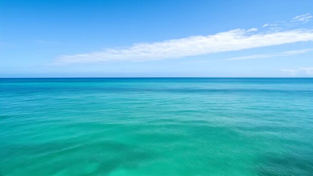 Infinite Horizon: Serene and tranquil, the sea stretches out to meet the sky in an idyllic scene. A band of fluffy clouds adds a touch of whimsy to the clear, bright blue expanse.