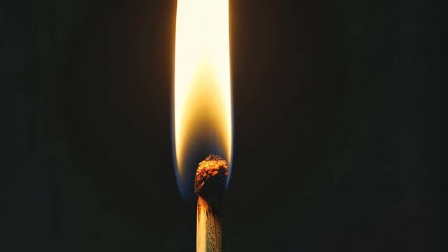 Burning match lights up darkness with intense flame in on black background, Burning match on a black background in