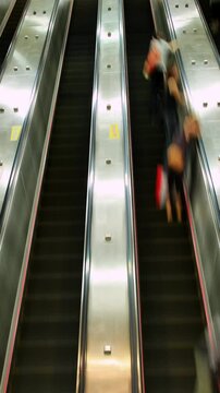 Hundreds of people zoom past on escalators. Time Lapse. Vertical Video.