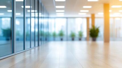 Obraz premium A modern, spacious office interior with glass walls, natural light, and potted plants creating a welcoming atmosphere.