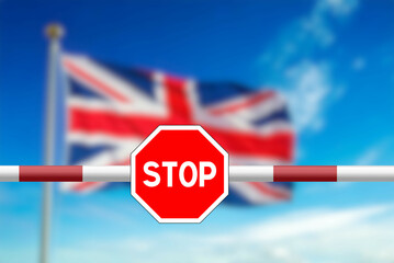 British border, flag of Great Britain and a border post with a barrier and stop sign	