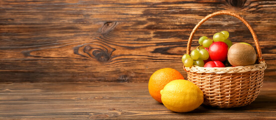Basket with fresh fruits on wooden background