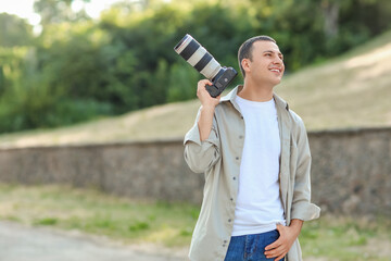 Male photographer with modern camera in park