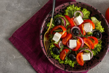 Bowl of tasty Greek salad on grey background, closeup