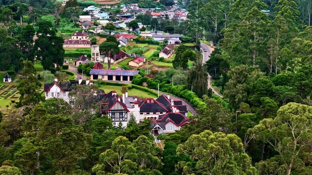 Drone aerial landscape of housing and buildings surrounded by forest trees in rural town street village valley of Nuwara Eliya Sri Lanka Asia travel tourism countryside acreage community