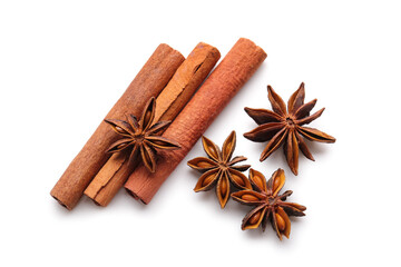 Star anise with cinnamon sticks on white background, top view