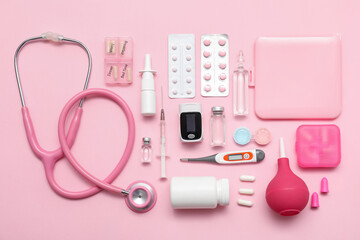 Composition with pulse oximeter, thermometer, stethoscope and medicines on pink background