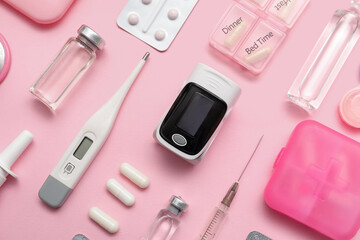 Composition with pulse oximeter, thermometer and medicines on pink background, closeup