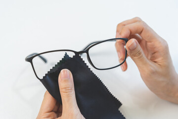 Cleaning glasses concept, close up hand of asian young woman hand holding frame of glass, use cloth...