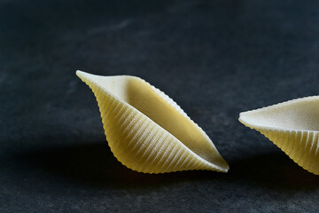 Ready to get Conchiglie. Close-up of a giant conchiglie pasta shell. Italian cuisine.