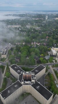 Aerial view of a modern cityscape with focus on tetragonal building and green spaces