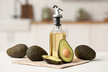 Bottle of fresh avocado oil on white table in kitchen