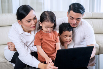 Caring Parents Teaching Their Children Using a Laptop at Home